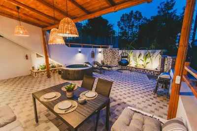 a patio with a table and chairs and a fireplace at Casa Zoe Luxurious Retreat in Archangelos