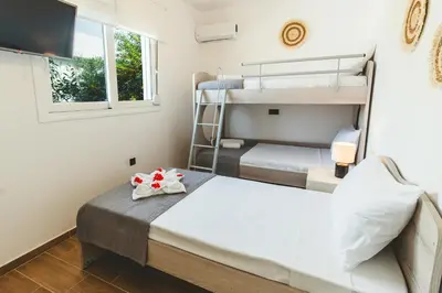 a bedroom with two bunk beds and a television at Casa Zoe Luxurious Retreat in Archangelos