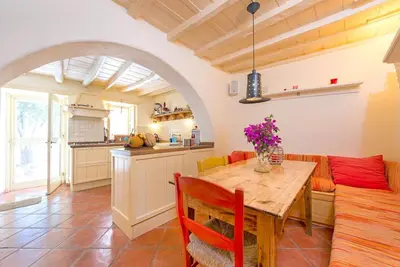 a kitchen and dining room with a wooden table and chairs at TheDreamHouse ChlorineFree Heated pool Artvillage in Koskinou