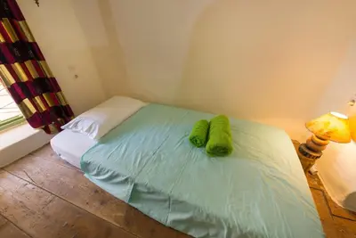 a bed with two green towels on top of it at TheDreamHouse ChlorineFree Heated pool Artvillage in Koskinou