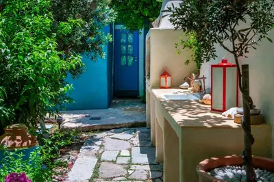 a pathway with a blue door and a tree and a house at TheDreamHouse ChlorineFree Heated pool Artvillage in Koskinou