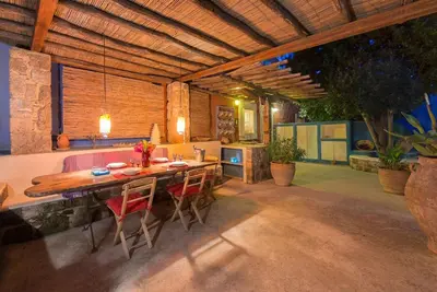 a dining room with a wooden table and chairs at TheDreamHouse ChlorineFree Heated pool Artvillage in Koskinou