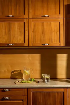 a kitchen with wooden cabinets and a counter with two glasses at Casa Arches, Rhodes in Archipolis