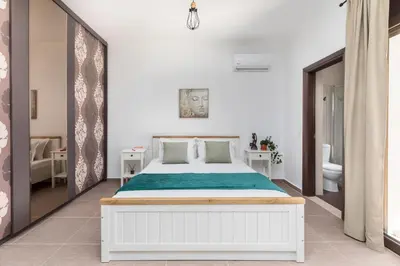 a bedroom with a white bed and a bathroom at Casa Arches, Rhodes in Archipolis