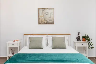 a bedroom with a white bed with a green blanket at Casa Arches, Rhodes in Archipolis
