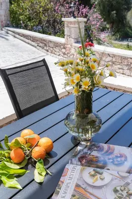 a vase filled with flowers and oranges on a table at Casa Arches, Rhodes in Archipolis