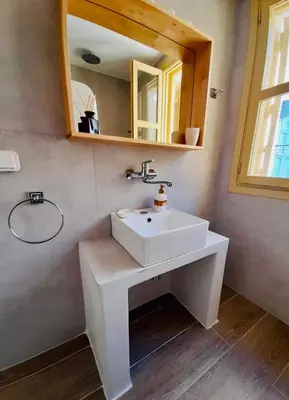 a bathroom with a white sink and a mirror at Aegli Apartments Deluxe in Symi