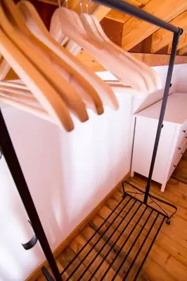 a white bed with a metal frame on a wooden floor at Aegli Apartments Deluxe in Symi