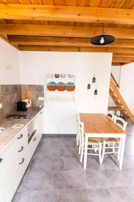 a kitchen with a wooden table and a wooden ceiling at Aegli Apartments Deluxe in Symi