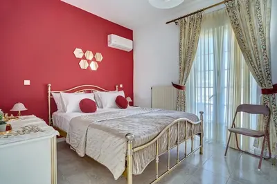 a red bedroom with a bed and a red wall at Chrysanthi Luxury Villa In Salakos, with Pool & Jacuzzi, Near Beach in Sálakos