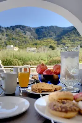 a table with plates of food and glasses of orange juice at Chrysanthi Luxury Villa In Salakos, with Pool & Jacuzzi, Near Beach in Sálakos