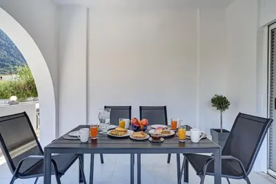 a table with breakfast foods and orange juice on it at Chrysanthi Luxury Villa In Salakos, with Pool & Jacuzzi, Near Beach in Sálakos