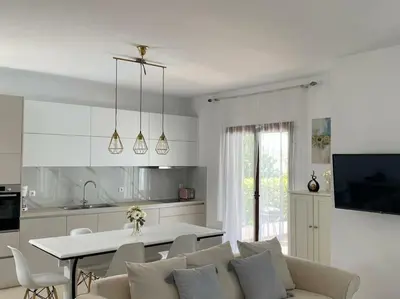 a kitchen and a living room with a couch and a table at Villa Sunshine very close to the beach in Líndos