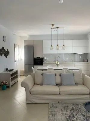 a living room with a couch and a kitchen at Villa Sunshine very close to the beach in Líndos