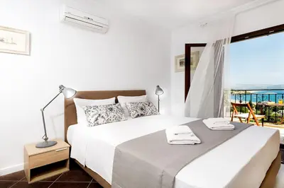a bedroom with a bed with a view of the ocean at Villa Sunshine very close to the beach in Líndos