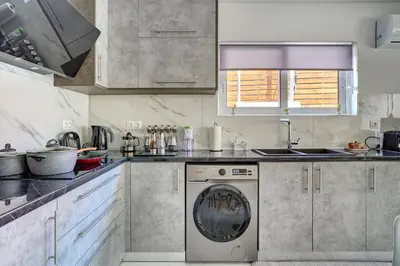 a kitchen with a washing machine in the middle at Sea & Joy House in Ialyssos