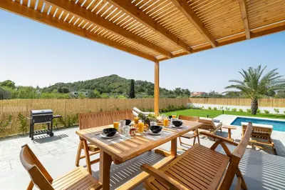 a patio with a table and chairs and a grill at Ixian Memory in Triánta