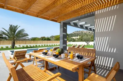 a wooden table and chairs on a patio at Ixian Memory in Triánta