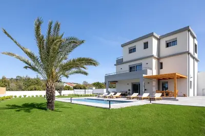 a villa with a palm tree and a swimming pool at Ixian Memory in Triánta