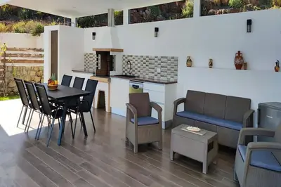a living room with a table and chairs and a kitchen at Sea View Villa Ellada, Just 3km From Lindos in Líndos