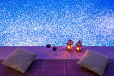 a table with two pillows and two candles next to a pool at Sea View Villa Ellada, Just 3km From Lindos in Líndos
