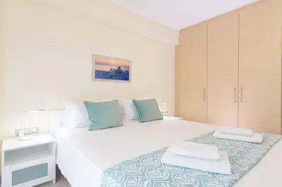 a white bedroom with a large white bed with towels on it at Sea View Villa Ellada, Just 3km From Lindos in Líndos