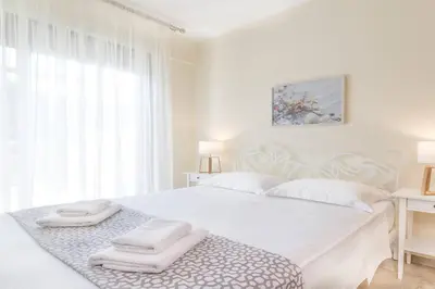 a white bedroom with a large bed with towels on it at Sea View Villa Ellada, Just 3km From Lindos in Líndos
