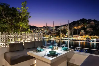 a balcony with a table and a view of the water at Annikas Port View-Ground in Symi