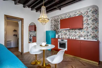 a kitchen with red cabinets and a table and chairs at Annikas Port View-Ground in Symi