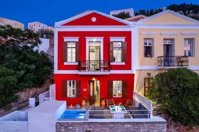 a red house with a staircase in front of it at Annikas Port View-Ground in Symi