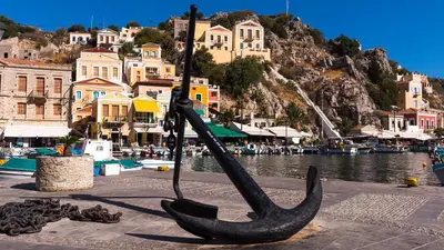 a statue of a boat on the side of a body of water at Annikas Port View-Ground in Symi