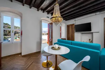 a living room with a blue couch and a table at Annikas Port View-Ground in Symi