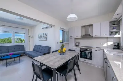 a kitchen and living room with a table and chairs at Nimarevi Apartment in Soroni