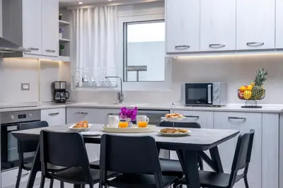 a kitchen with a table and chairs with food on it at Nimarevi Apartment in Soroni