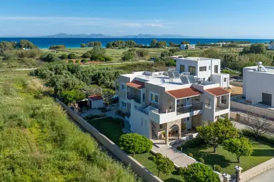 an aerial view of a white house with the ocean in the background at Nimarevi Apartment in Soroni