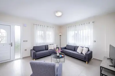 a living room with two blue couches and a table at Nimarevi Apartment in Soroni