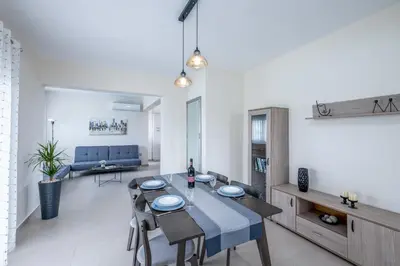 a dining room and living room with a table and chairs at Nimarevi Apartment in Soroni