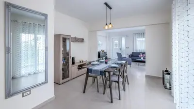 a kitchen and living room with a table and chairs at Nimarevi Apartment in Soroni
