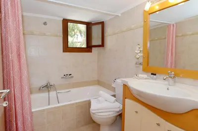 a bathroom with a tub and a sink and a toilet at Captain Ilias House Chalki in Halki