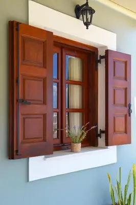 an open window with a potted plant on a window sill at Captain Ilias House Chalki in Halki
