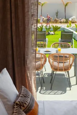 a patio with chairs and a table and a table and chairs at Lago Beach Living in Faliraki