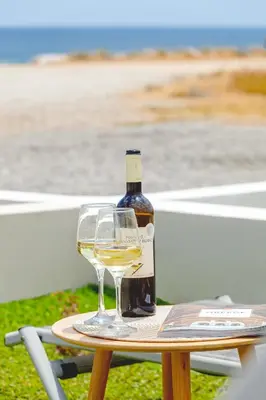 a bottle of wine sitting on a table with a glass at Lago Beach Living in Faliraki