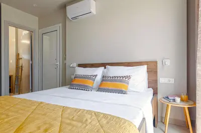 a bedroom with a white bed with two pillows at Lago Beach Living in Faliraki