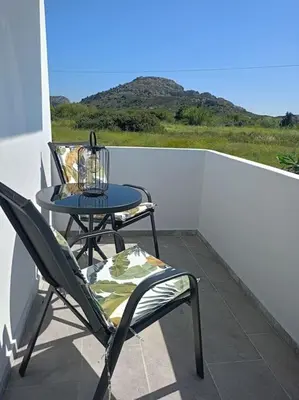 a patio with a table and chairs on a balcony at Blue Sky Villa in Kalithies