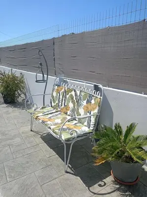 a bench sitting on a patio next to a wall at Blue Sky Villa in Kalithies