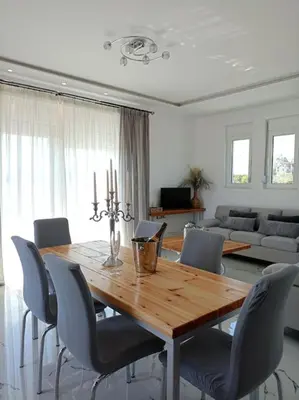 a dining room with a wooden table and chairs at Blue Sky Villa in Kalithies