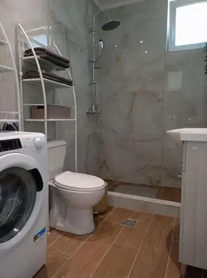 a bathroom with a toilet and a washing machine at Blue Sky Villa in Kalithies
