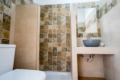 a bathroom with a sink and a toilet and a mirror at Farkia Exclusive Studios in Faliraki