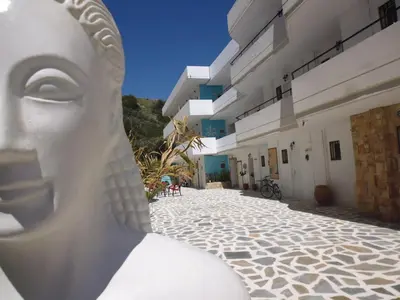 a statue of a woman sitting on a cobblestone street at Farkia Exclusive Studios in Faliraki
