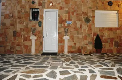 a room with a white door and a stone wall at Farkia Exclusive Studios in Faliraki